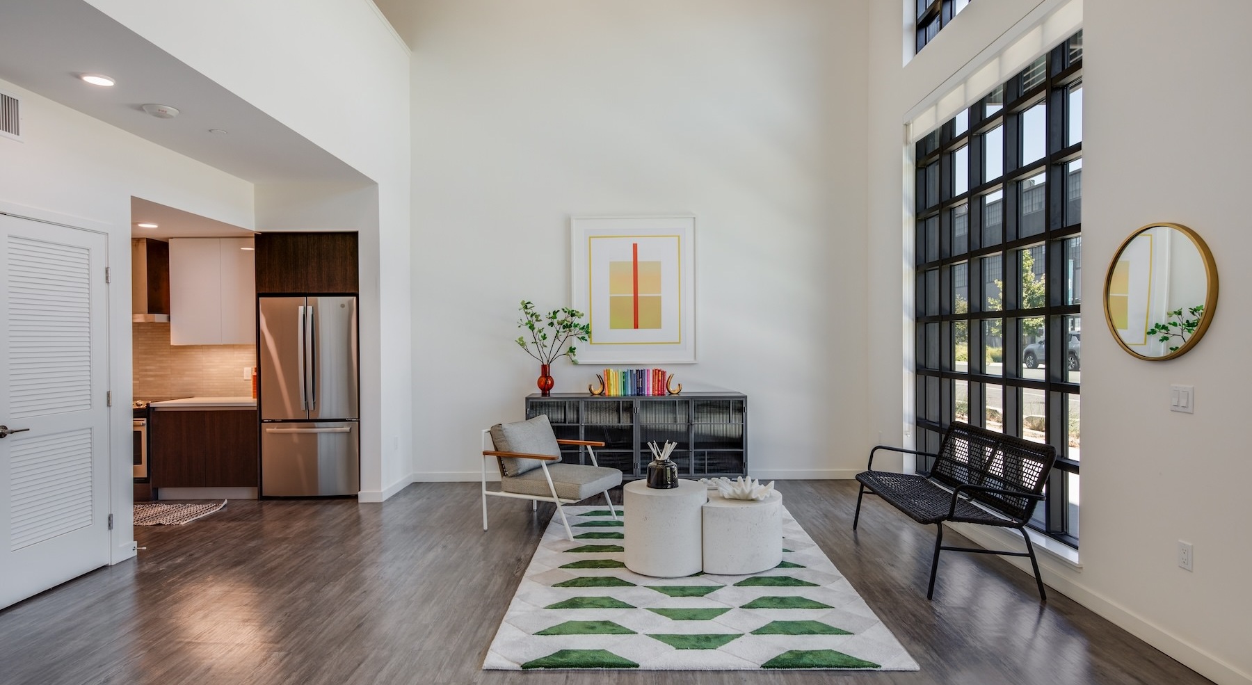 a room with large windows, chairs and a desk with a chair