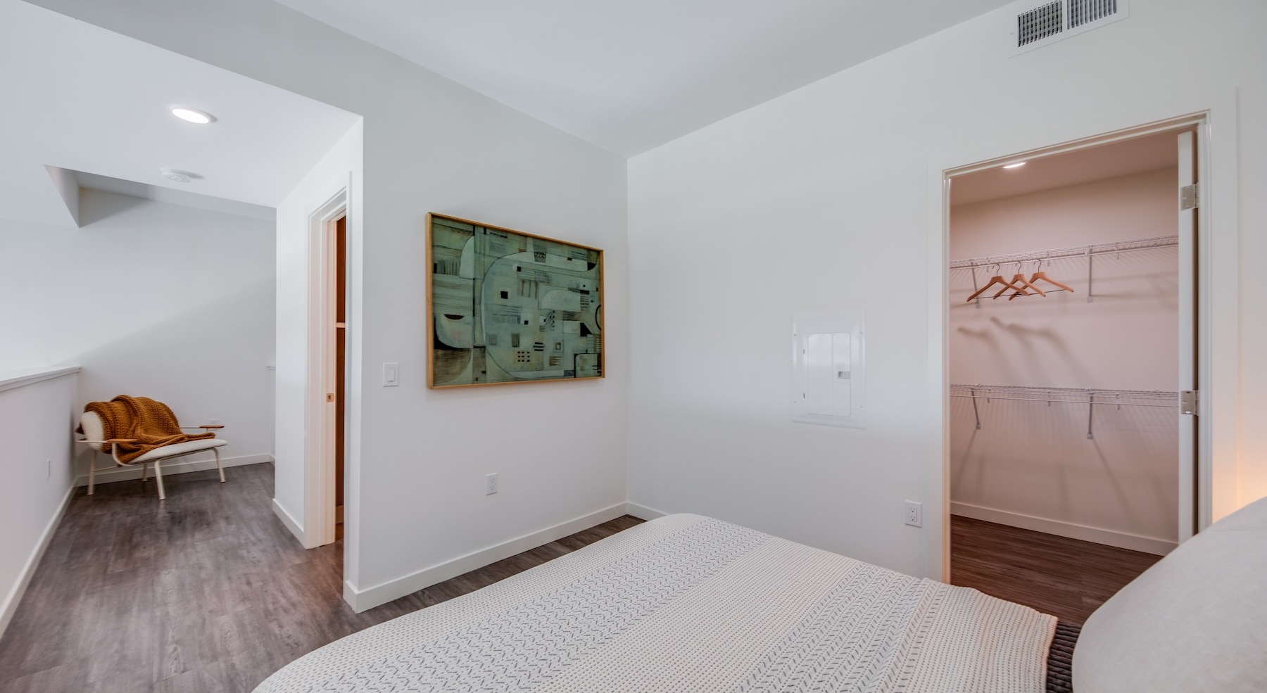 a room with a bed and a picture on the wall next to a closet