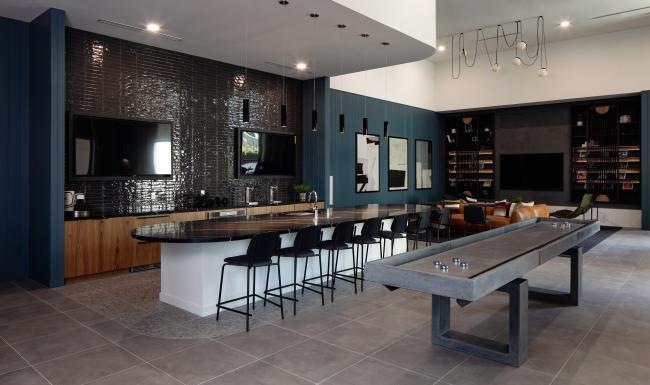 Settle into comfort at Launch a kitchen with a bar and chairs