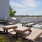 a deck with a grill, tables and chairs