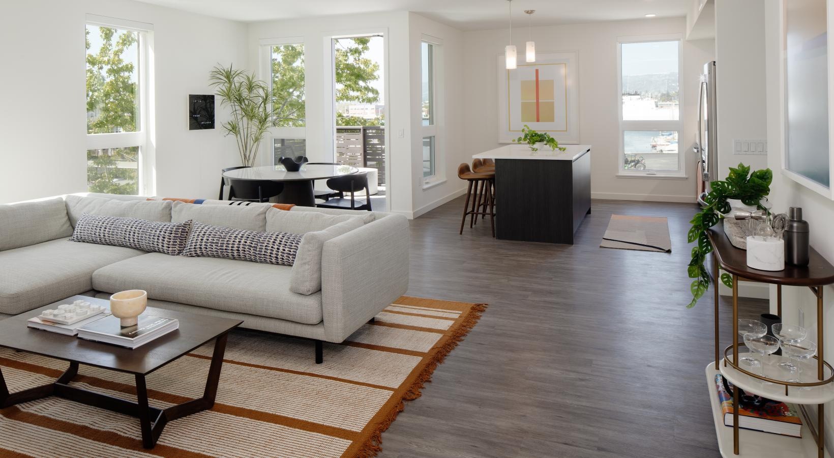Spacious and well-lit living spaces a large living room with a large white couch and a table